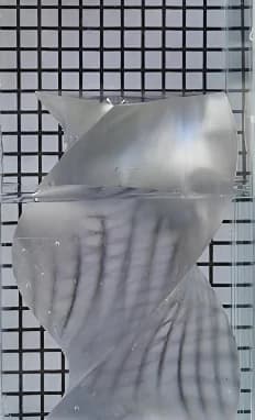 물에 담근 비틀린 각기둥 모델. 투명해졌지만 배경 격자가 심하게 휘고 끊겨 보인다.